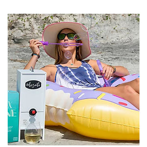 Woman enjoying her wine tasting beverage dispenser on the beach